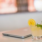 a glass of liquid with a lemon slice on a table